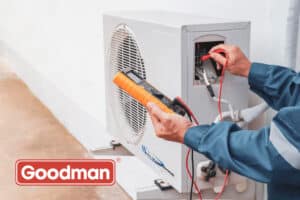 Technician using a multimeter on a Goodman air conditioning unit, emphasizing professional AC installation and maintenance services.