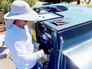 Technician performing emergency HVAC repair on rooftop unit in Phoenix, AZ, highlighting 24/7 service for urgent heating issues.
